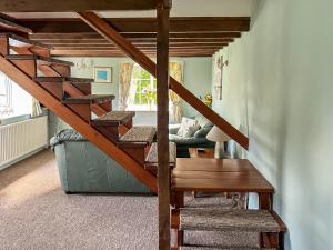 a spiral staircase in a living room with a couch at Commonwealth Cottage in Iron Acton