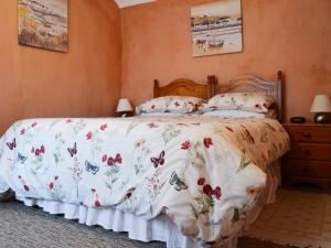 a bedroom with a bed with a floral bedspread at Commonwealth Cottage in Iron Acton +4 photos