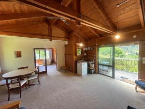 a large living room with a table and a kitchen at Abel Tasman guest house in Marahau