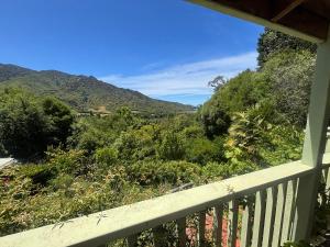 a balcony with a view of the mountains at Abel Tasman guest house in Marahau