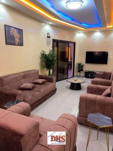 a living room with couches and a flat screen tv at DHS Home in Pikine