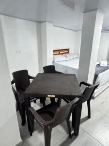 a room with a table and chairs and a bed at Hotel ZT in Mariquita