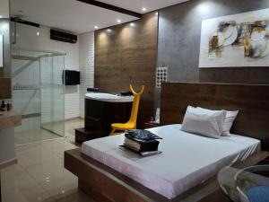 a bedroom with a bed and a bathroom with a shower at Segredos in Araras