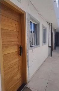 a wooden door of a building next to a corridor at Lofts Baronesa in São José dos Campos