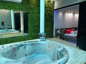 a bathroom with a jacuzzi tub with a bedroom at Segredos in Araras