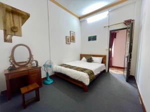 a bedroom with a bed and a mirror and a dresser at Sunlit Homestay Sapa in Sapa