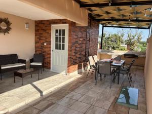 a patio with a table and chairs and a brick wall at Casa con Alberca en condominio in Yautepec de Zaragoza