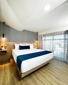 a bedroom with a large bed and a large window at Rest Inn Baja in Ensenada