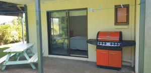 a small house with a stove and a window at Lazy Daze at Athenree in Waihi Beach