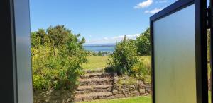 a view from the window of a house at Lazy Daze at Athenree in Waihi Beach +3 photos