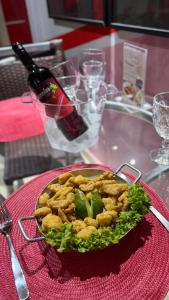 a plate of food on a table with a bottle of wine at Segredos in Araras
