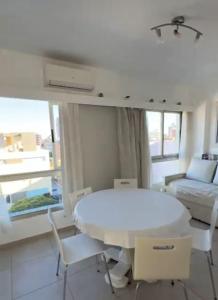 a white living room with a white table and chairs at CoSTA Y MAR II in Villa Gesell