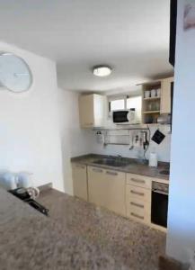 a small kitchen with a stove and a microwave at CoSTA Y MAR II in Villa Gesell +3 photos