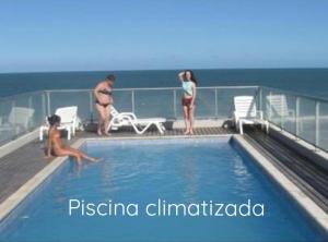 a group of people standing around a swimming pool on a cruise ship at CoSTA Y MAR II in Villa Gesell