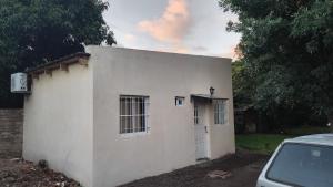 a small white building with a door and a car at Mi sueño apart en Mercedes Corrientes!!! in Mercedes