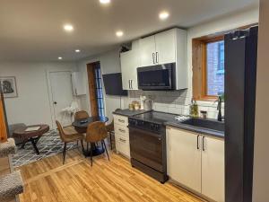 a kitchen with white cabinets and a table and a counter top at La Pergola-4 in Quebec City