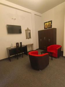 a room with two chairs and a table and a tv at Colonial Plaza Hotel in Puno