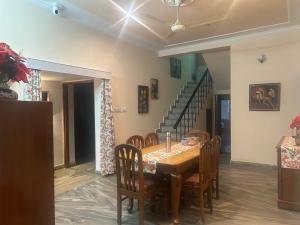 a dining room with a table and chairs and a staircase at Smriti- loving memories in Jaipur
