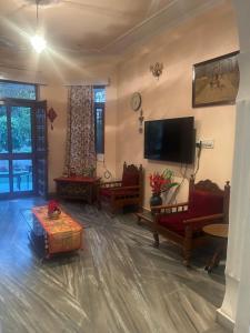 a living room with couches and a flat screen tv at Smriti- loving memories in Jaipur