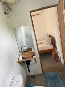 ein Badezimmer mit Waschbecken, Spiegel und Toilette in der Unterkunft Kategha Beach Guesthouse in Praia do Tofo