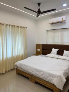 a bedroom with a bed and a ceiling fan at MR Homes in Cochin