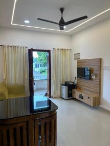 a living room with a couch and a ceiling fan at MR Homes in Cochin