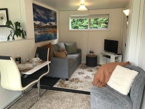 a living room with a couch and a table at Brookside Country Escape 40 minutes to CHC Airport in Leeston