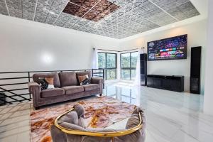 a living room with a couch and a tv at Sunset Havendale in Kingston