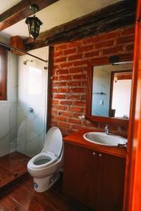a bathroom with a toilet and a sink and a mirror at Solarium Cabaña in Riobamba