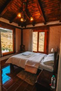 a bedroom with a bed in a room with windows at Solarium Cabaña in Riobamba