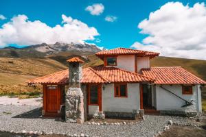 a small house with a mountain in the background at Solarium Cabaña in Riobamba