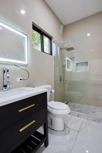 a bathroom with a toilet and a sink and a shower at Sunset Havendale in Kingston +4 photos