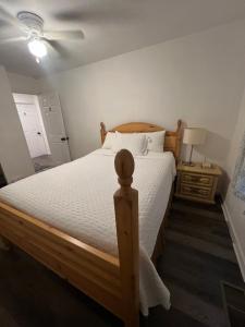 a bedroom with a wooden bed with a white bedspread at Near Red Mountain park in Mesa