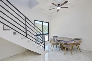 a dining room with a table and chairs and a staircase at Sunset Havendale in Kingston