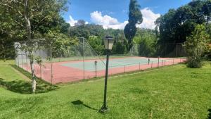 a tennis court with a street light in the grass at Recanto Itapeva Garden in Itapeva