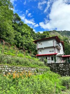 a house on a hill with a stone wall at Abbotsford Prasada Bhawan in Nainital