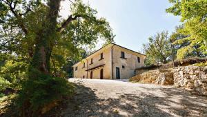 un bâtiment sur une route à côté d'un mur de pierre dans l'établissement Chalet Colle Lo Zoppo, à Arpino