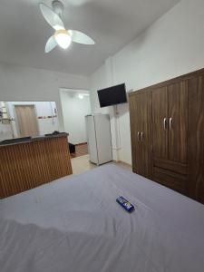 a bedroom with a bed with a remote control on it at Studio em Piedade in Rio de Janeiro