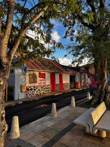a bench in front of a building on a street at Studios Soleil du Sud in Sainte-Anne