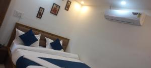 a bedroom with a bed with blue and white pillows at Hotel 7R RESIDENCY in Jhānsi