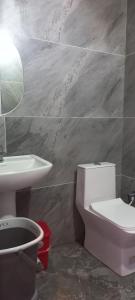 a bathroom with a toilet and a sink at Hotel 7R RESIDENCY in Jhānsi +4 photos