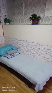 a bed in a room with a white wall at Ingeritch Cabin Transient and Homestay in Baguio