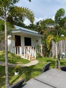a small white house with palm trees in a yard at Kalipay Bungalows Alcoy in Alcoy