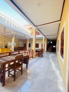 a restaurant with wooden tables and chairs and a balcony at Nongkhiaw Chansai Guesthouse in Nongkhiaw