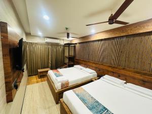 ein Zimmer mit zwei Betten und einem Flachbildfernseher in der Unterkunft Hotel Keys Elite in Vijayawāda