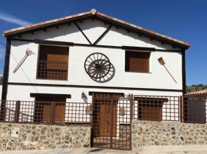 a white building with a wheel on the side of it at Casa Rural El Pajar de Puchero in Ruidera