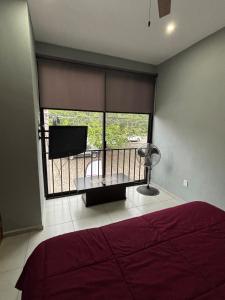 a bedroom with a bed and a large window at C apartment in Ajijic