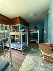 a room with three bunk beds and a table at Peach Haven in Cebu City