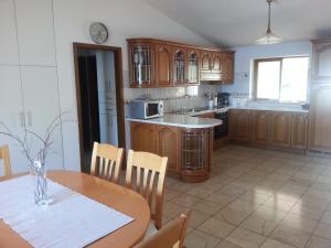 a kitchen with wooden cabinets and a table with a vase at Apartment Palma in Korčula