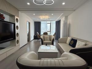 a living room with couches and a flat screen tv at JOYINN HOTEL Guangzhou Zoo Shaheding Metro Branch & Guangzhou Beijing Road Pedestrian Street & Canton Fair Nearby 桔迎酒店-广州动物园沙河顶地铁站店 in Guangzhou
